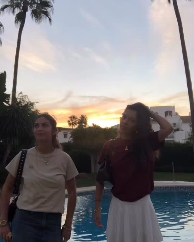 To kvinder ved en pool i solnedgang i Nevani t-shirts.